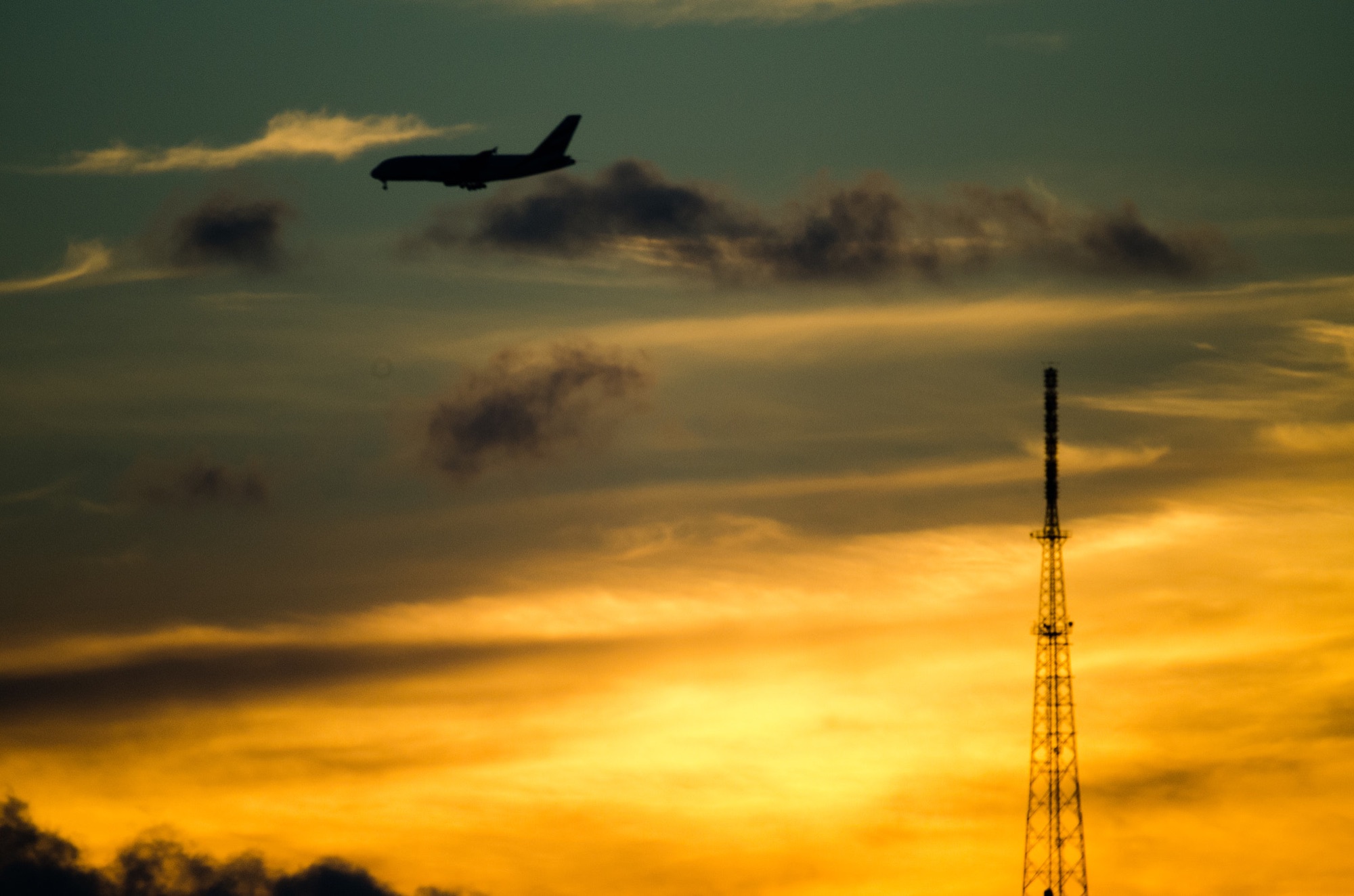 An Airbus A380 silhouetted against a gold sunset